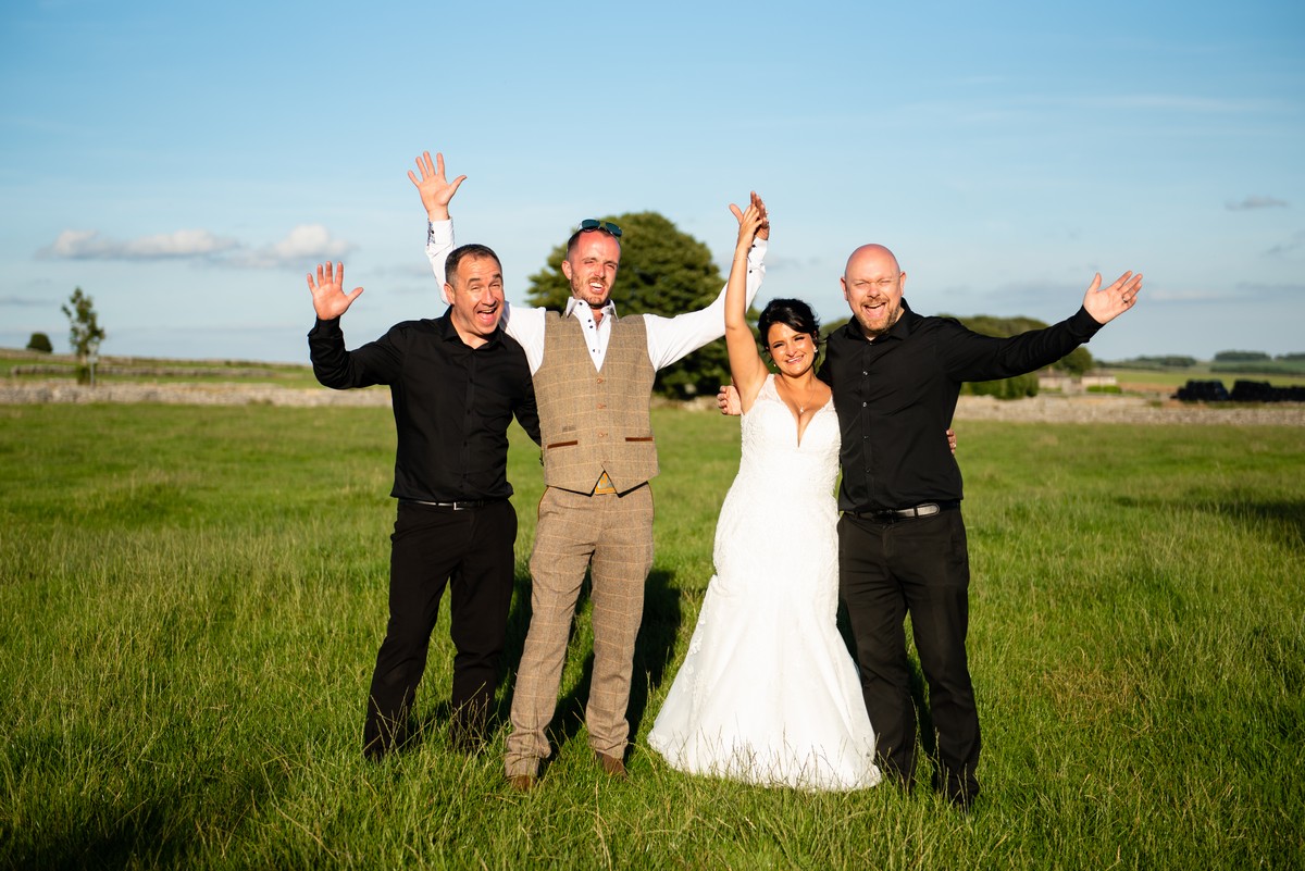 Bride and groom celebrating outdoors with The Sing Along Waiters® after an amazing performance.